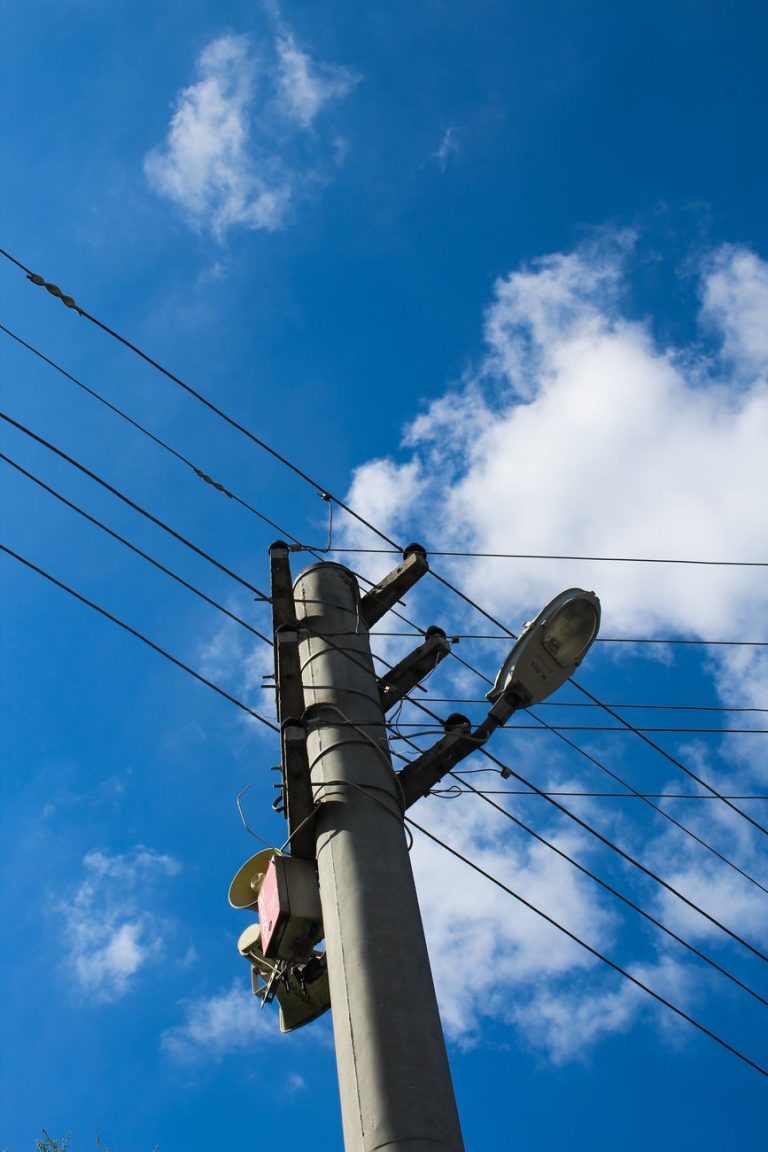 a street light and telephone pole with a blue sky