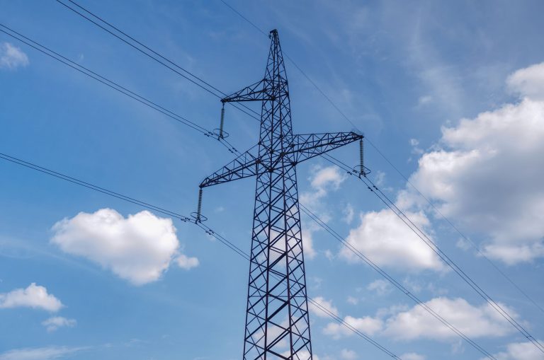high voltage transmission tower against blue sky