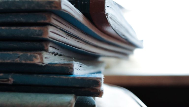 piled soft bound books on table